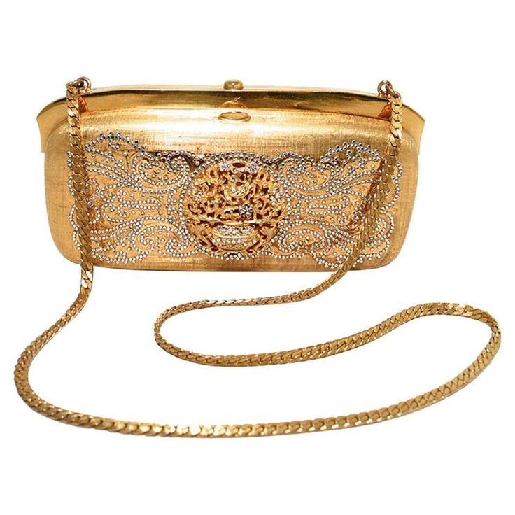 Stunning Judith Leiber Vintage gold box minaudiere in very good vintage condition. Gold structured box exterior trimmed with clear swarovski crystals and an attached gold chain shoulder strap. Top button closure opens to a gold leather lined interior that has two separate compartments. No stains, smells, or missing crystals. Light scuffs inside from use and age. This piece is perfect for any formal occasion as it coordinates with any wardrobe choice and will add the perfect amount of sparkle to Oscar Dela Renta, Sparkly Purse, Judith Leiber Handbags, Judith Leiber Bags, Gold Gallery, Structured Handbags, Elegant Clutch, Clear Handbags, Vintage Evening Bags