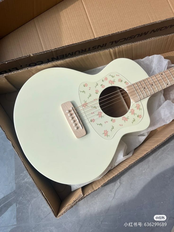 an open box with a white guitar in it