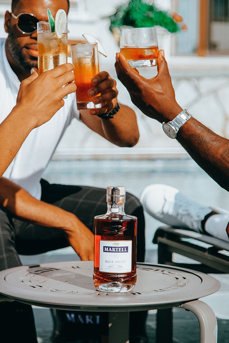 three men toasting with drinks in front of them