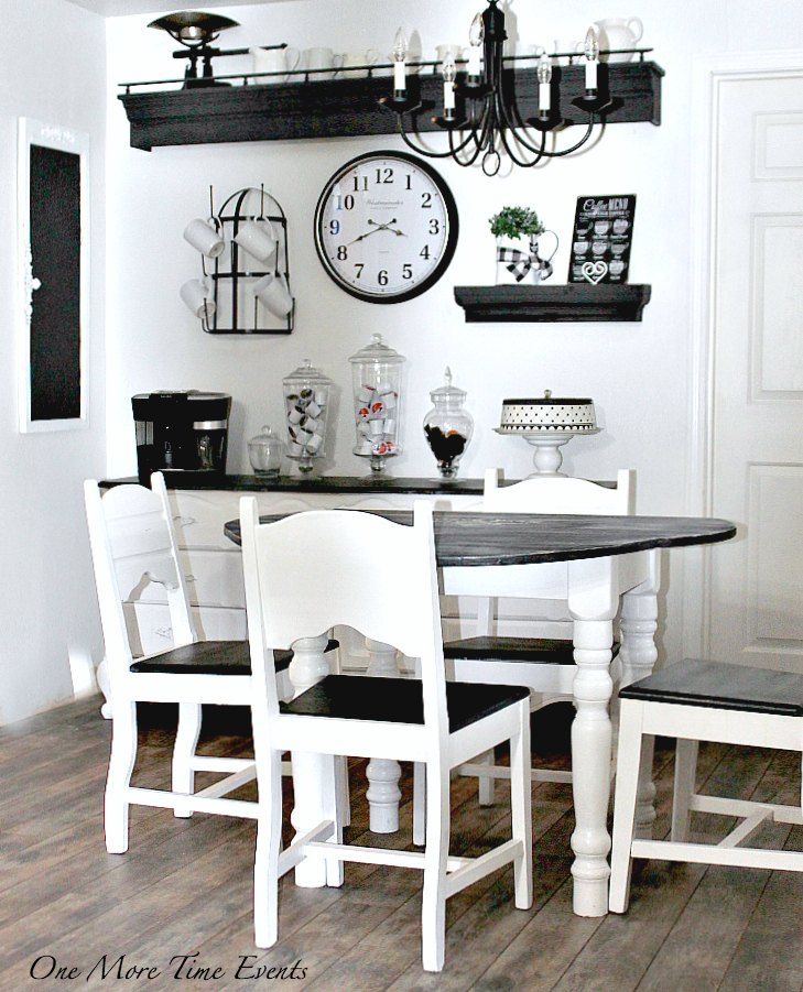 a dining room table with four chairs and a clock on the wall