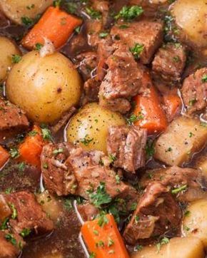 beef stew with carrots, potatoes and parsley in a bowl