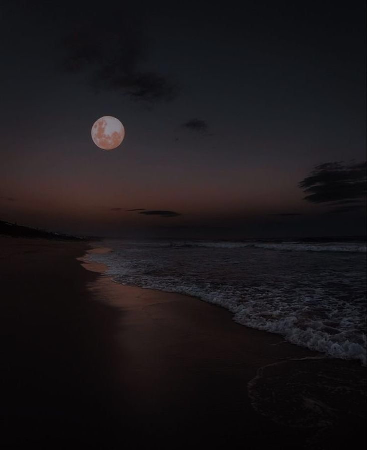 the moon is setting over the ocean with waves coming up to it's shore