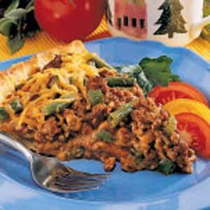 a blue plate topped with meat and veggies next to a cup of coffee