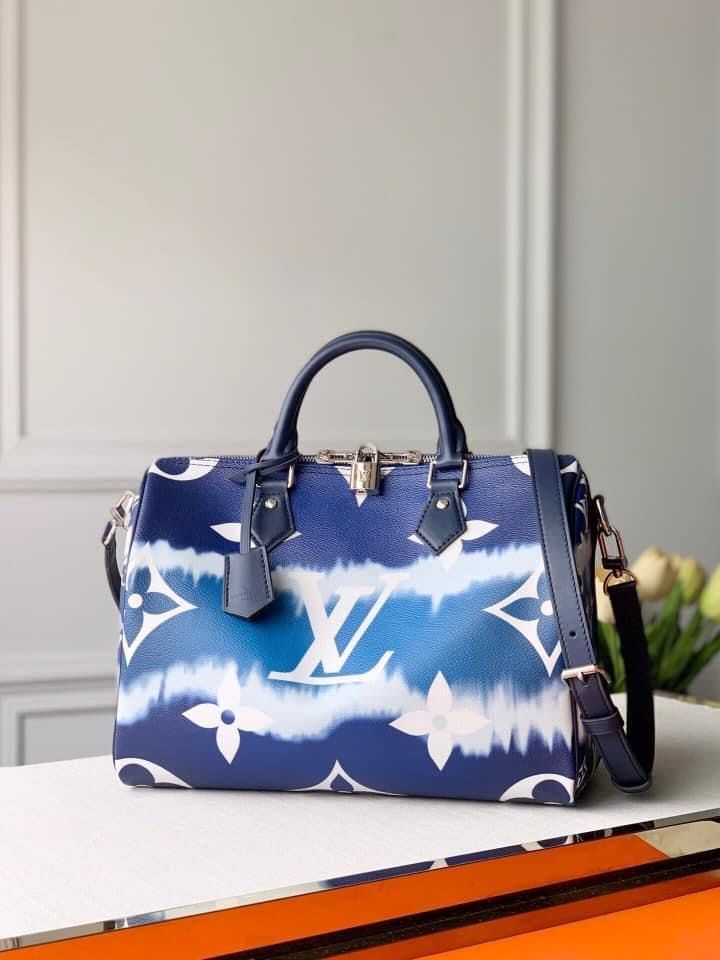 Tie-Dye Monogram canvas brings a beachy feel to the Speedy Bandoulière 30, a classic Louis Vuitton city bag relooked for the LV Escale Collection. The rolled-leather handles and distinctive shape make this bag immediately recognizable while the removable strap offers the option of comfortable shoulder carry. It’s signed with the iconic engraved padlock. Detailed Features 30 x 21 x 17 cm (Length x height x width ) Blue Monogram coated canvas Cowhide-leather trim Textile lining Silver-color hardware Lockable double zipped closure Pocket lined with textile D-ring to hang keys or pouches Strap: Removable, adjustable Strap Drop: 48.0 cm Strap Drop Max.: 55.0 cm Handle: Double Speedy Bandouliere 30, Speedy Bandouliere, Louis Vuitton Keepall, Louis Vuitton Wallet, Duffle Bag Travel, City Bag, Vuitton Bag, Handle Bag, Vuitton Handbags