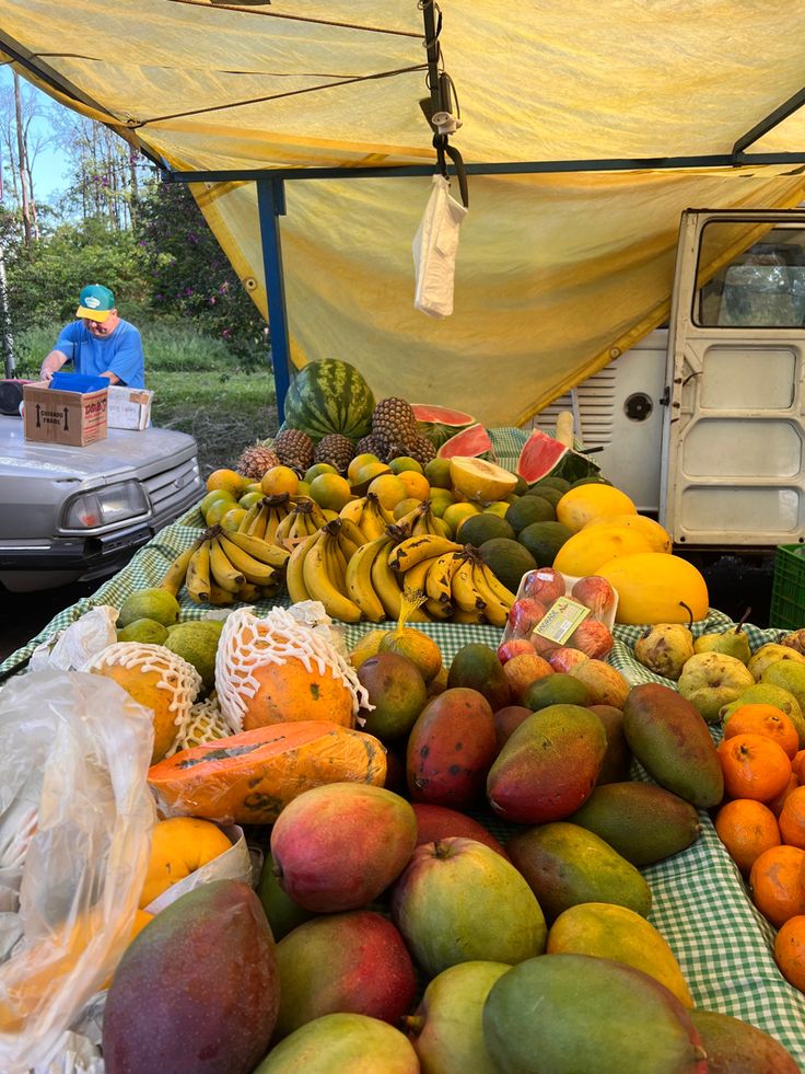 there are mangoes, oranges and other fruits on display at the farmers market