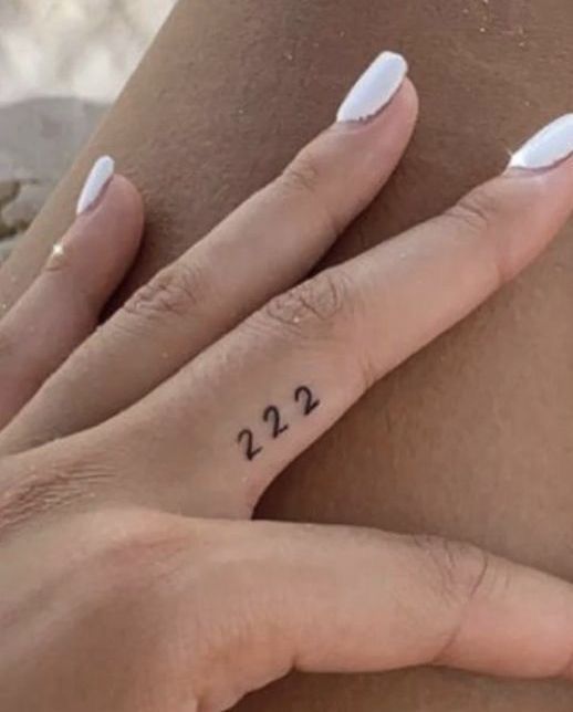 a woman's hand with a small tattoo on her left wrist and the number 22