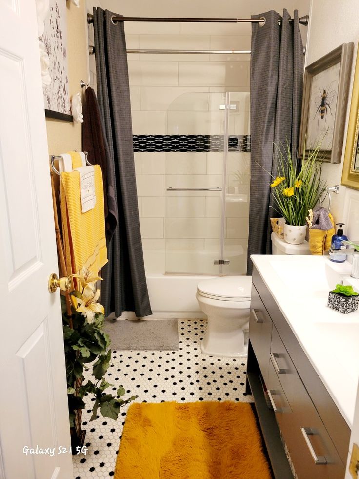 a white toilet sitting next to a bathroom sink under a shower curtain in a bathroom