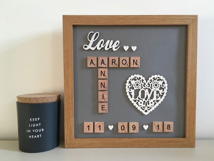 a wooden scrabble frame sitting next to a cup