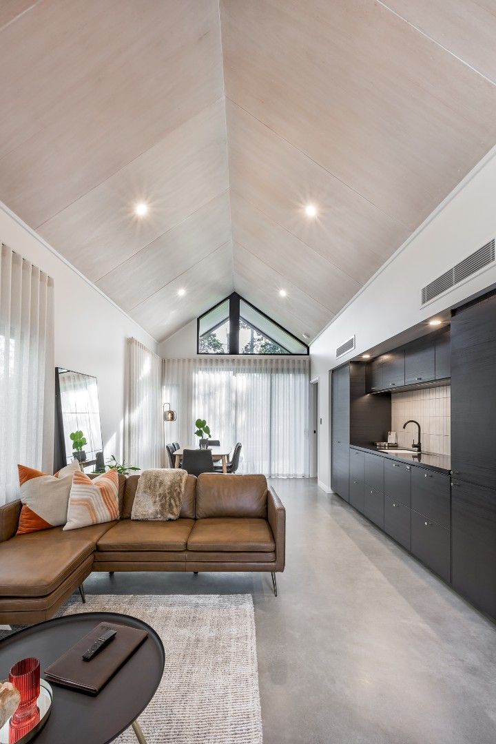 a living room filled with furniture next to a kitchen