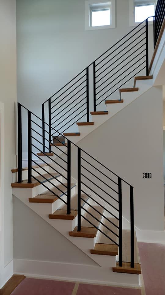 a white staircase with black handrails in a house