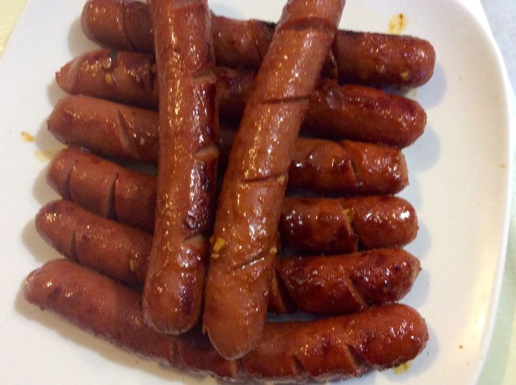 several sausages on a white plate ready to be eaten