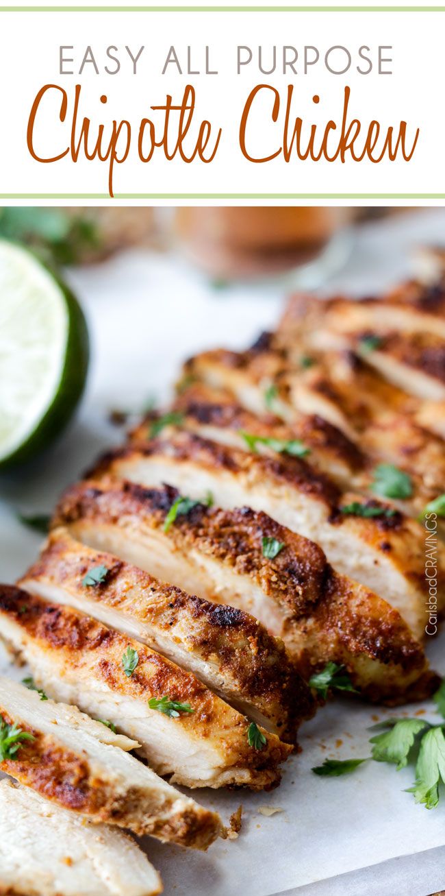 sliced chicken breast with parsley and lime on cutting board next to lemon wedges