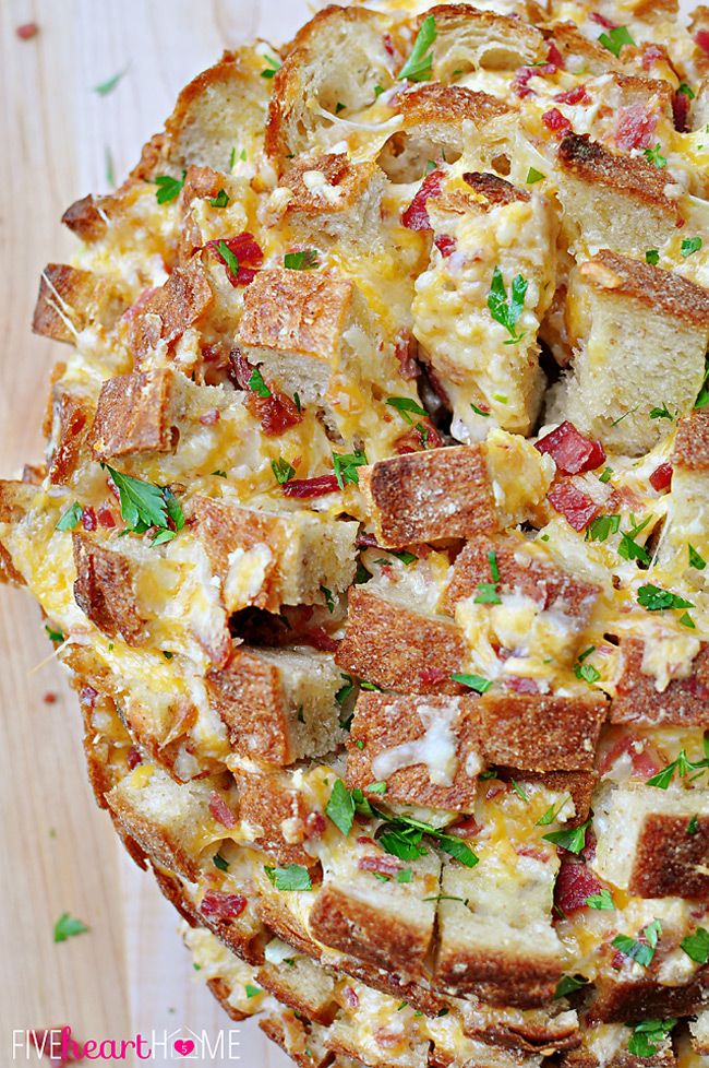 a pizza sitting on top of a wooden table covered in cheese and bacon toppings