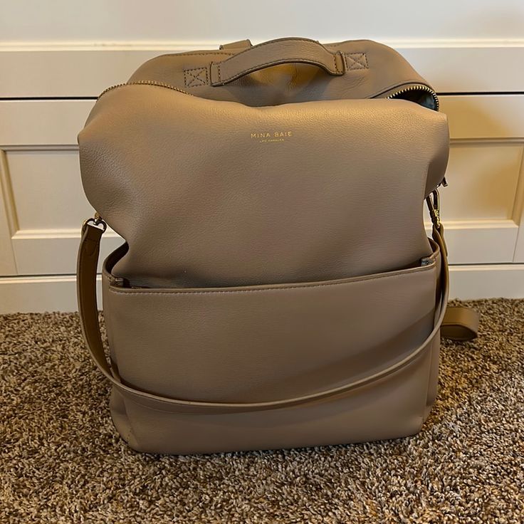 This Diaper Bag Was An Absolute Dream. So Many Pockets, Plenty Of Space And You Can Wear It As A Backpack Or On The Shoulder. It Is Used But Still In Great Condition! There Is Some Slight Cracking On The Top Handle Which I Included A Picture Of. It’s In The Color Sand. Chic Soft Leather Backpack For Errands, Luxury Beige Leather Backpack For Everyday, Leather Backpack With Detachable Strap For Errands, Everyday Large Capacity Satchel Backpack, Large Capacity Daily Satchel Backpack, Daily Large Capacity Satchel Backpack, Large Capacity Leather Satchel Backpack For Errands, Chic Soft Leather Travel Backpack, Everyday Chic Rectangular Backpack