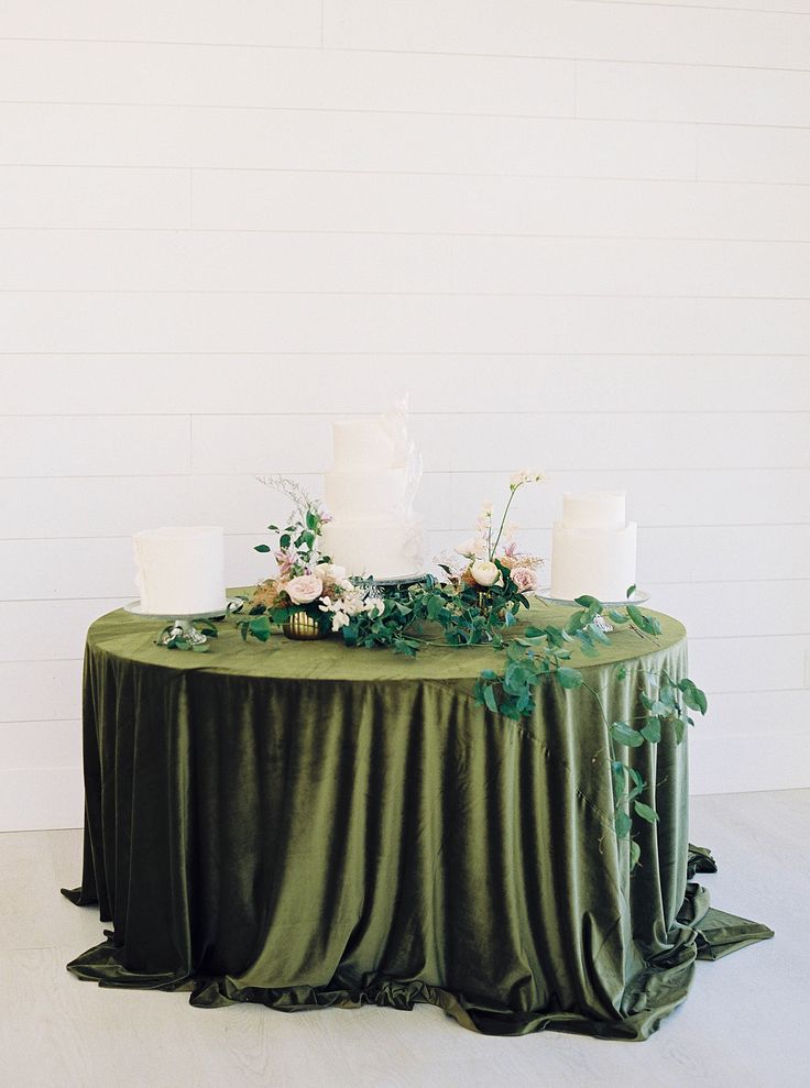 the table is covered with green cloth and white candles