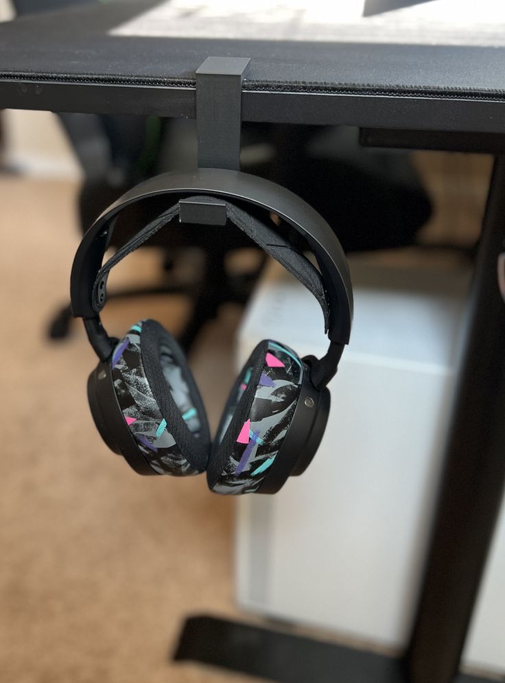 a pair of headphones hanging from the side of a table in an office setting