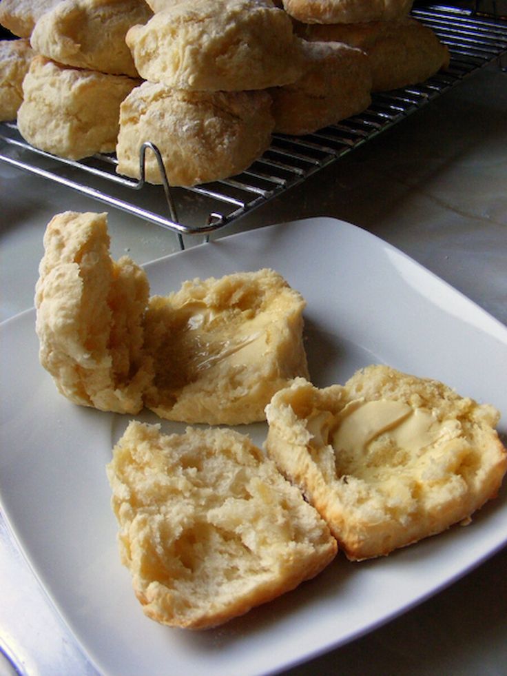 several pastries are sitting on a white plate next to a rack with other pastries