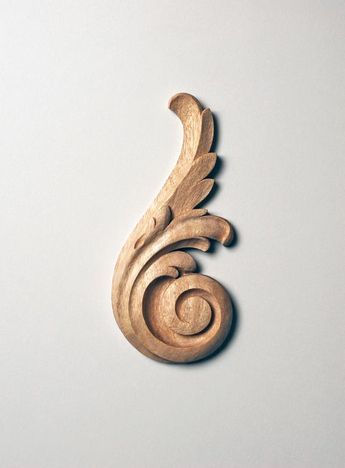 a carved wooden object sitting on top of a white surface