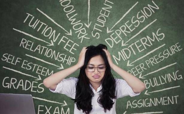 a woman sitting in front of a laptop computer with words written on the wall behind her