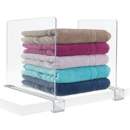 a stack of towels sitting on top of a glass shelf