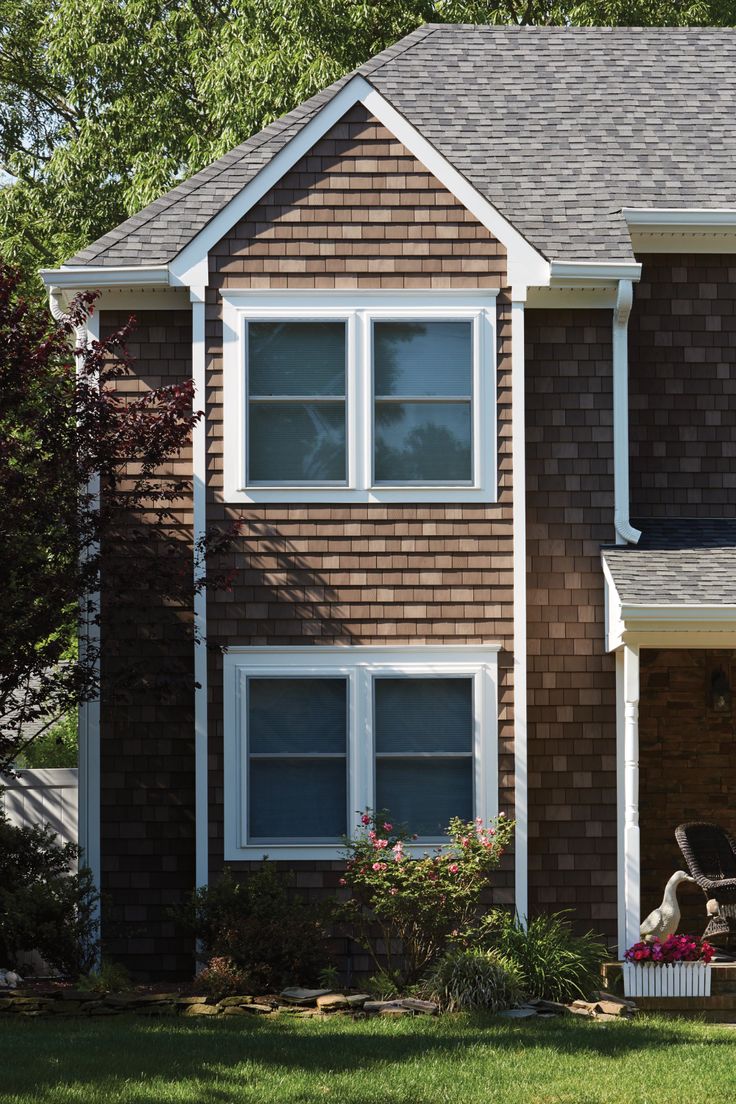 a brown house with white trim and windows