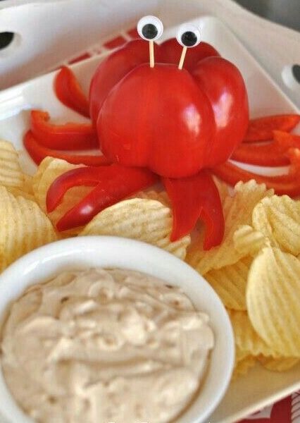 a plate topped with chips and a red crab