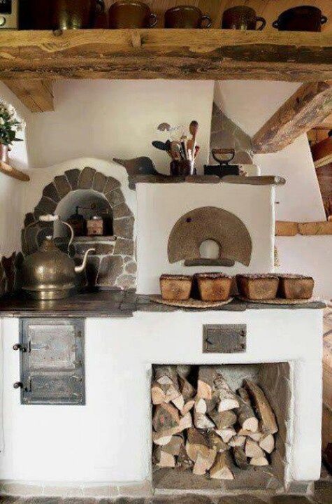 an old fashioned oven with wood stacked in it