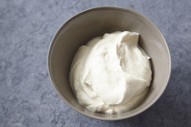 a bowl filled with cream sitting on top of a table