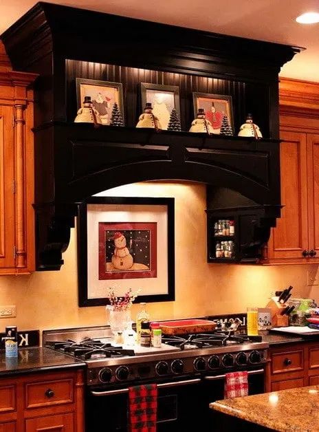 a kitchen with wooden cabinets and black stove top oven, pictures on the wall above it