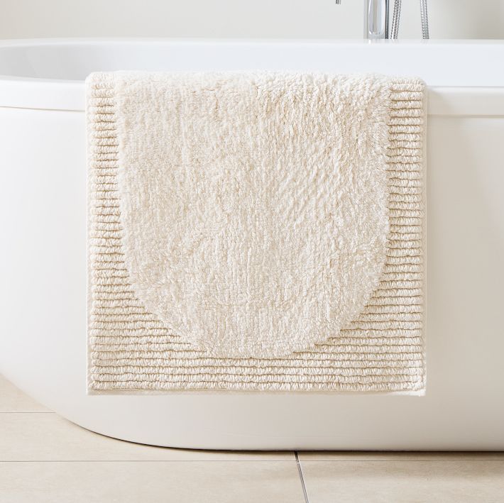 a white bath mat sitting on top of a tub