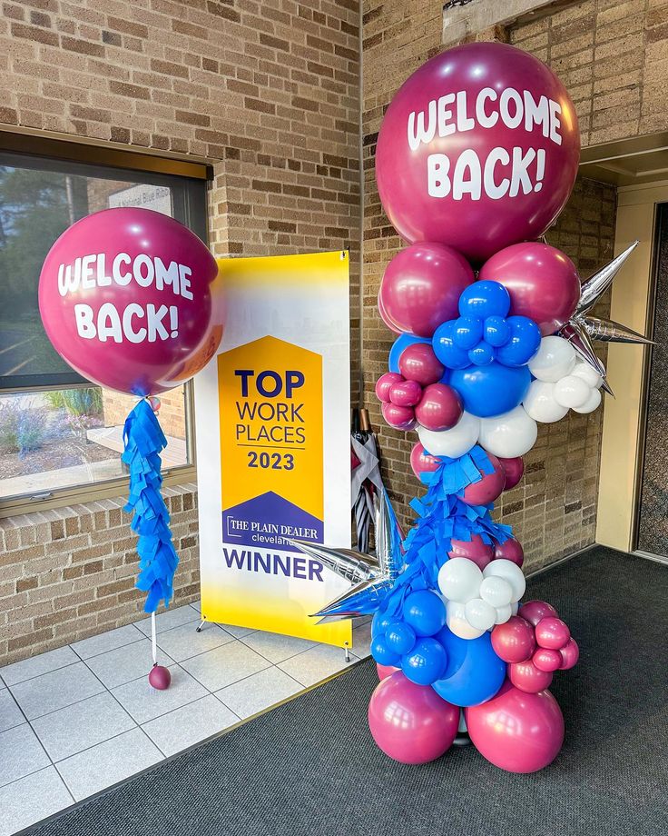 balloons and welcome back signs in front of a brick building