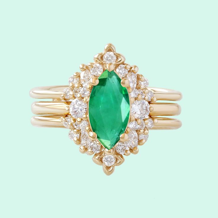 an emerald and diamond ring on a green background