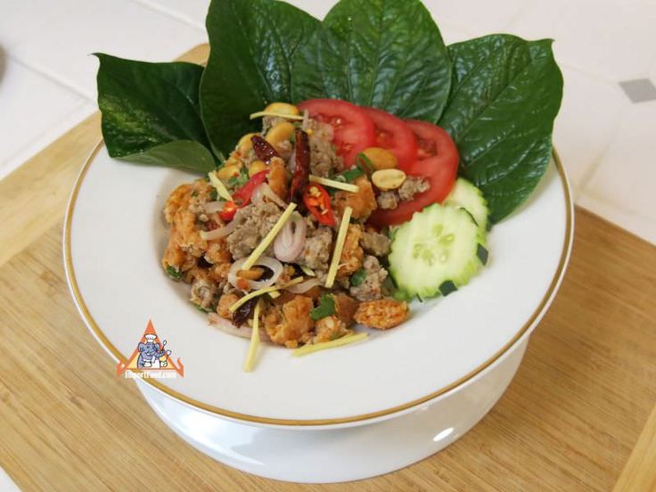 a white bowl filled with food on top of a wooden table