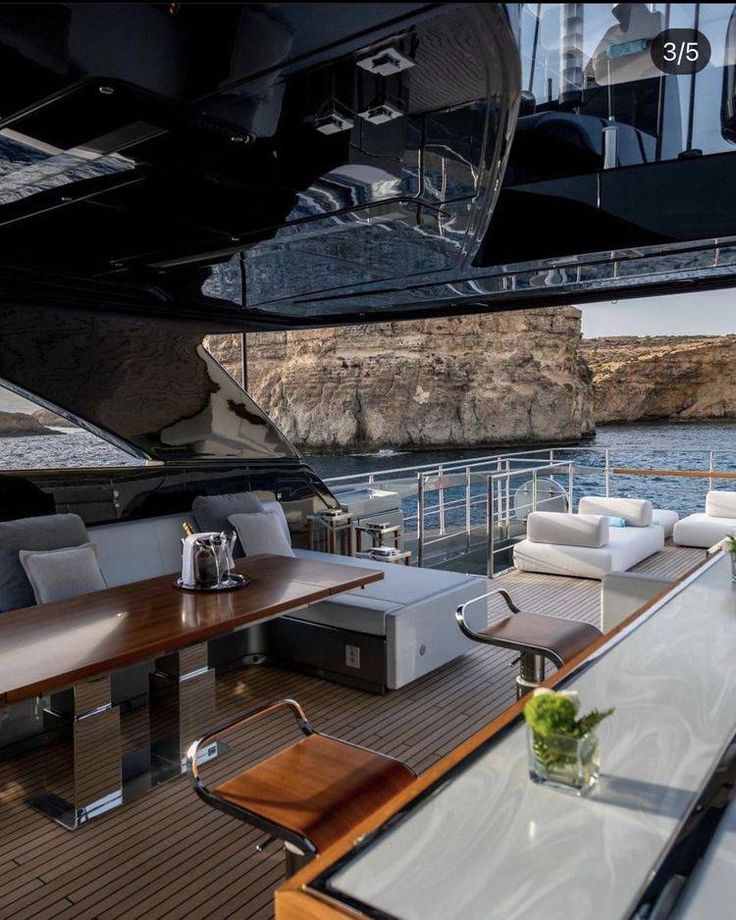 the inside of a boat with tables and couches on it's deck area