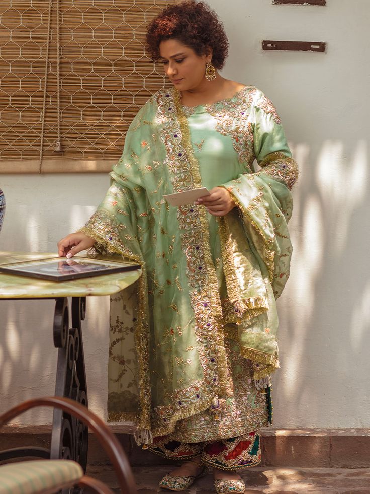 Explore sophistication in a light green raw silk long shirt with full sleeves. Paired with flappers in the same hue, this ensemble is elevated with an organza dupatta in a matching shade. Ideal for Pakistani formal occasions, it exudes timeless elegance and contemporary style.In the realm of attire, emerges a garment adorned in the gentle and refreshing hue of Light Green�a color that invokes the serenity of a spring morning. Meticulously tailored from the luxurious embrace of raw silk fabric, t Zardozi Work, Raw Silk Fabric, Classic Outfit, Pakistani Fashion Party Wear, Organza Dupatta, Embroidery Suits, Silk Dupatta, Silk Pants, Kurta Designs