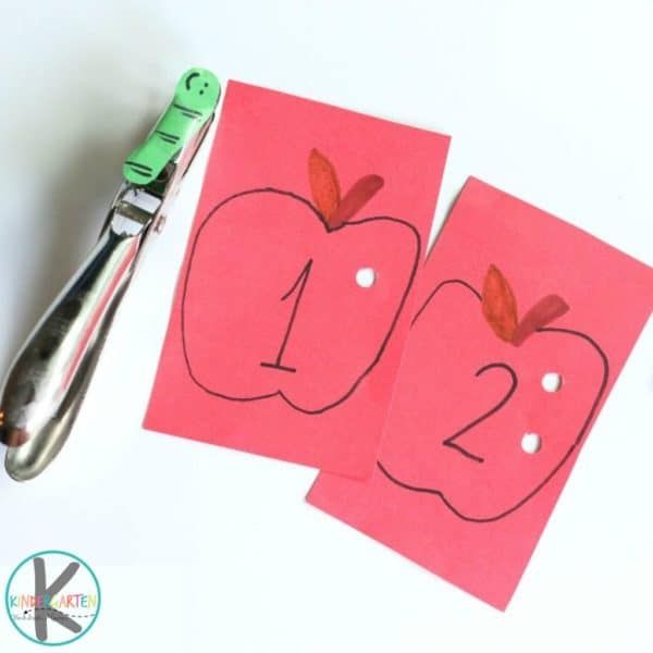 two pieces of paper cut out to look like apples with scissors next to them on a white surface