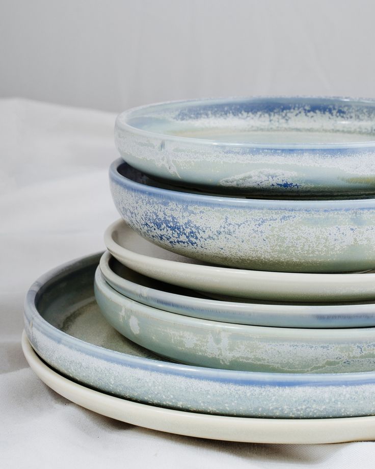 four blue and white plates stacked on top of each other