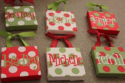 six personalized gift boxes tied together with green and red polka dot ribbon on the floor