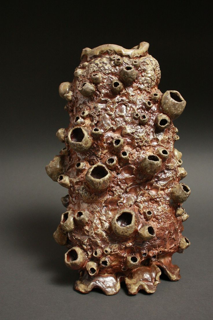 a sculpture made out of clay with lots of holes in the middle and small holes at the bottom