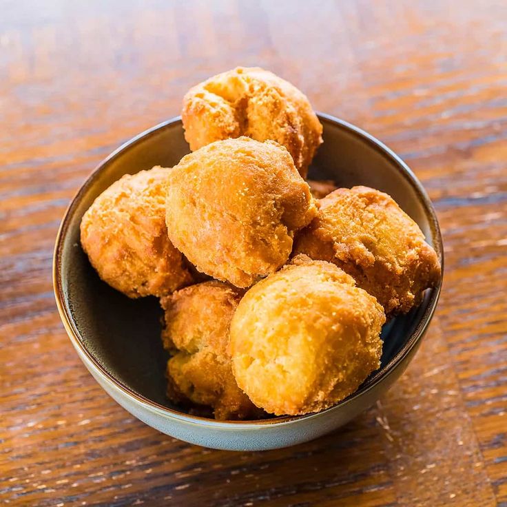 a bowl filled with fried food on top of a wooden table