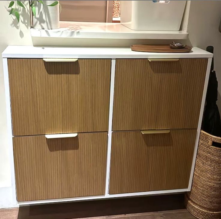 a white and brown cabinet with drawers next to a basket