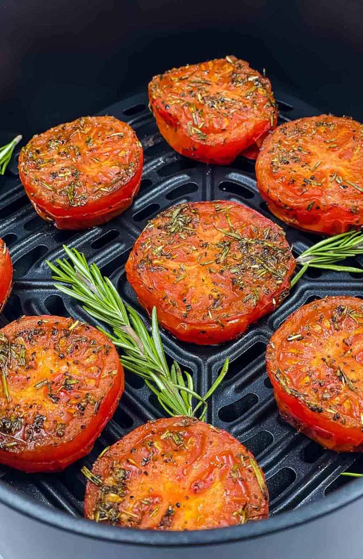 tomatoes with herbs and rosemary cooking in an air fryer