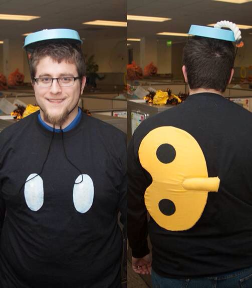 two men wearing t - shirts with smiley faces and headphones on their heads, standing in an office setting