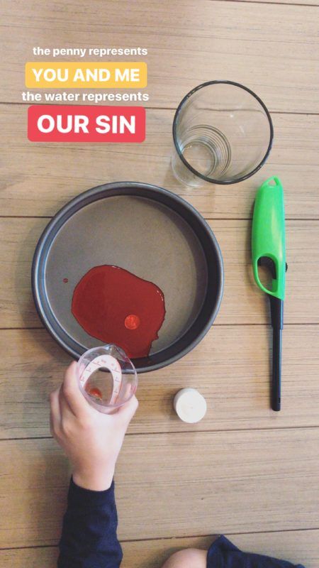 a person pouring red liquid into a pan on top of a wooden table next to a green spatula