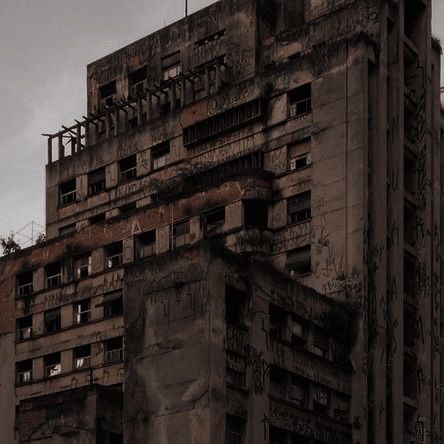 an old building with lots of windows and graffiti on it