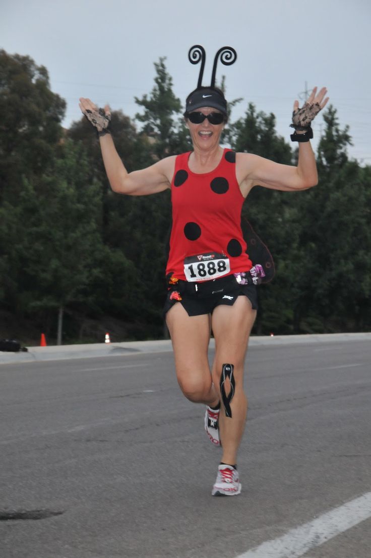 a ladybug costume running in a marathon with her hands up to the side