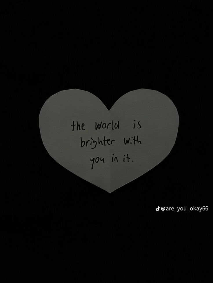 the world is brighter with you in it written on a heart - shaped piece of paper