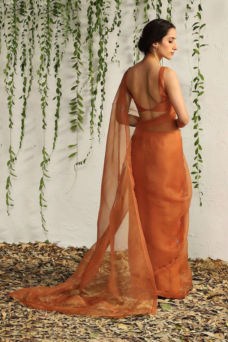 Editor's Note Crafted in feather touch pure organza fabric in a rich spice orange colour and intricate nakshi hand embridery inspired by the leaf motif, this saree looks like a dream. A deep ne... Luxury Orange Embroidered Saree, Luxury Unstitched Orange Saree, Luxury Orange Pre-draped Saree For Diwali, Luxury Embroidered Orange Saree, Luxury Orange Saree With Unstitched Blouse, Luxury Orange Saree For Diwali, Luxury Orange Anarkali Saree, Saree Poses Photoshoot Ideas, Wedding Guest Saree