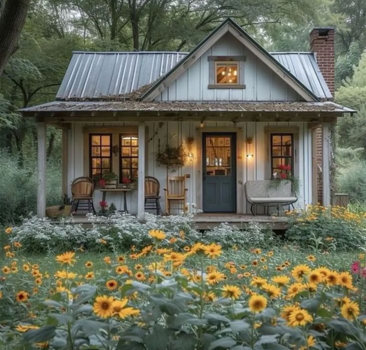 a small house with sunflowers in the front yard