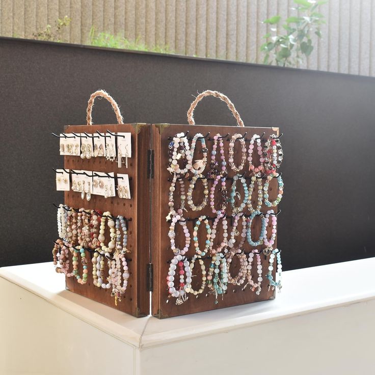 two brown bags with bracelets on them sitting on a table next to each other